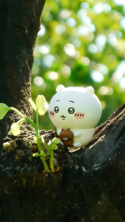 吉伊卡哇抱著小熊玩偶坐在陽光斑駁的樹枝上的治癒系高清手機桌布